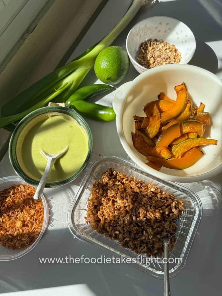 overhead shot of roasted squash, savory tofu crumble, crunchy nuts, fried shallots, and green scallion dressing