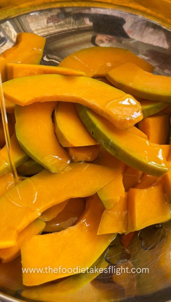 Drizzling olive oil on sliced squash