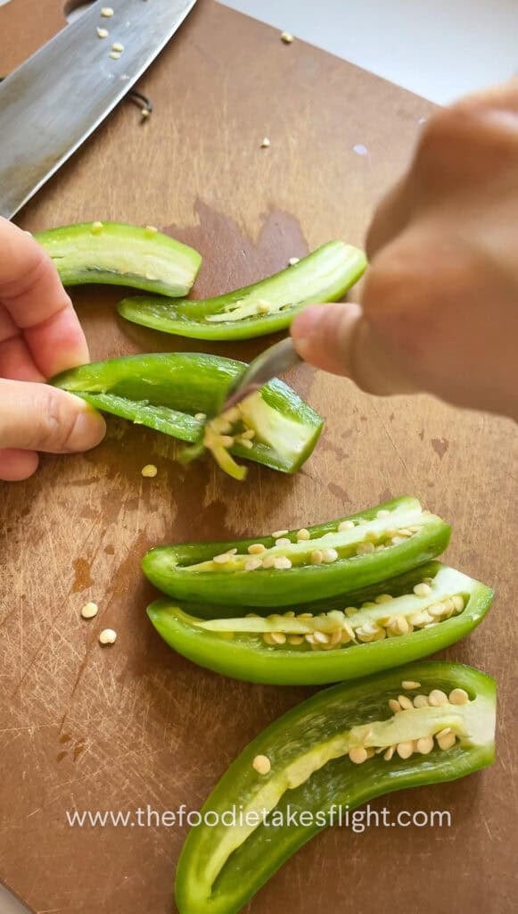 Scooping seeds out of serrano peppers