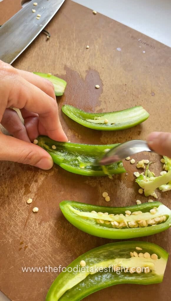 Scooping seeds out of serrano peppers