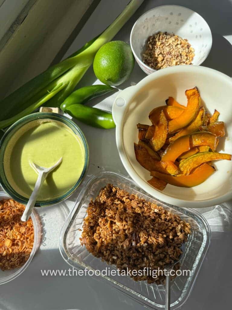 overhead shot of roasted squash, savory tofu crumble, crunchy nuts, fried shallots, and green scallion dressing