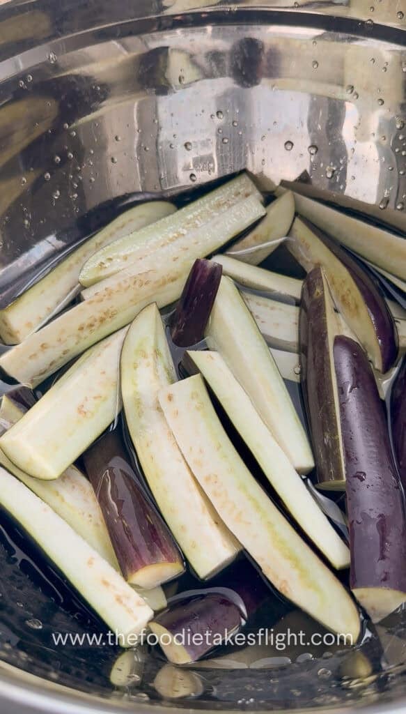 Sliced chinese eggplant in batons soaked in salted water