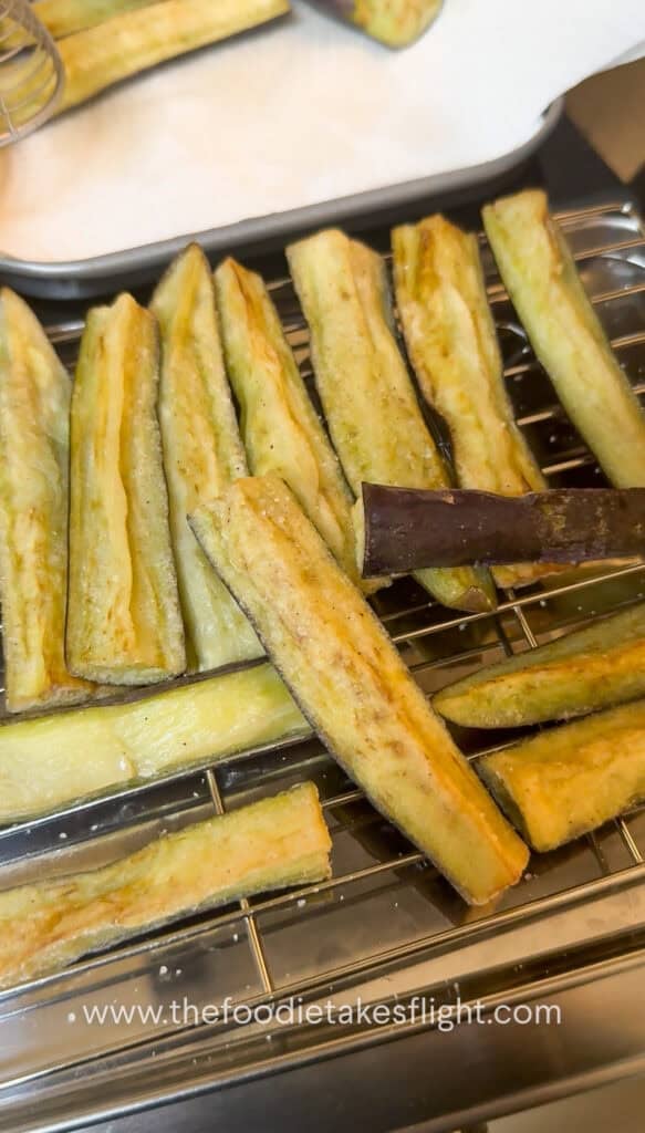 Lightly golden fried eggplant draining on a tray