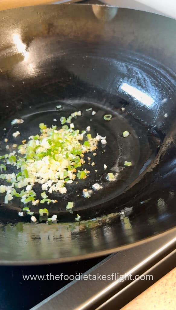 Ginger, garlic, and Sichuan peppercorn sizzling in a wok