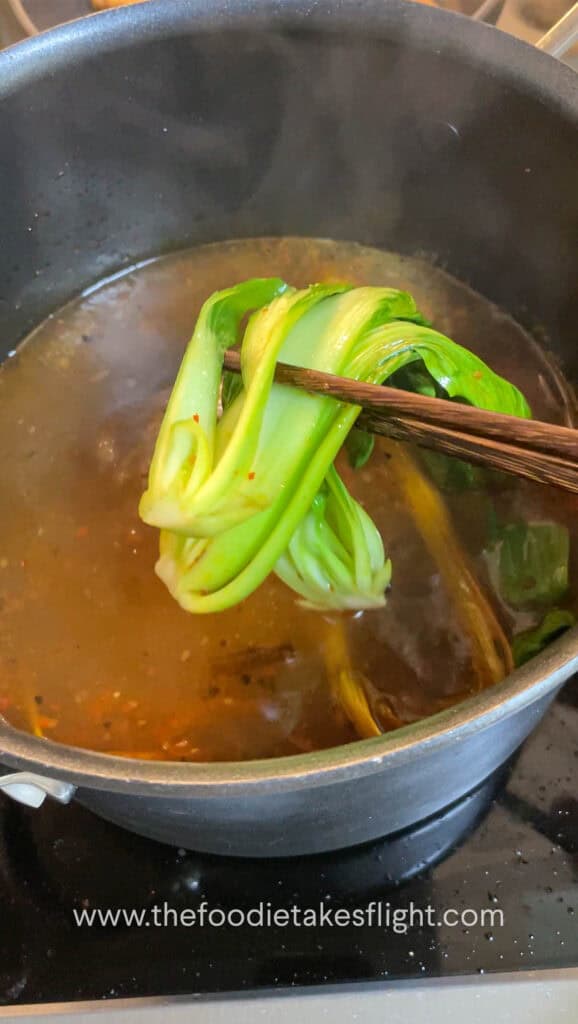 Blanching the bok choy in soup pot