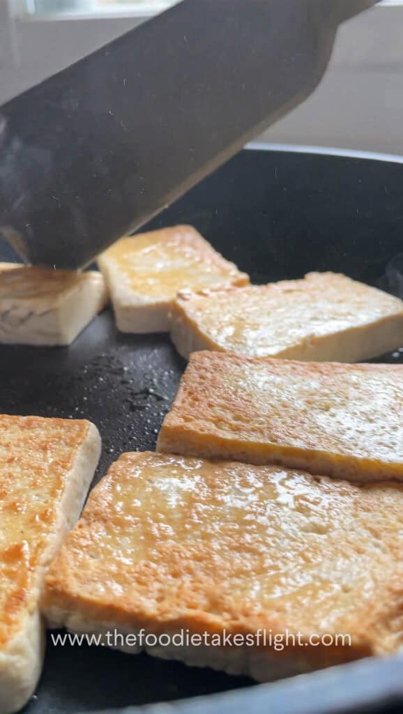 Pan frying extra firm tofu in a skillet until golden brown
