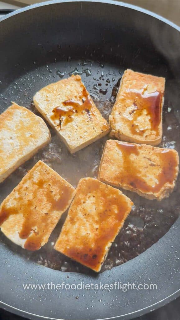 Pan-fried golden tofu in a skillet