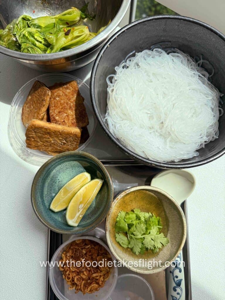 A flat lay of spicy lemongrass coconut noodle soup ingredients