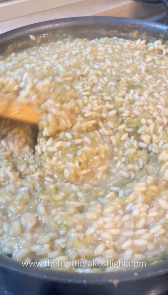 arborio rice slowly cooking down in a pan