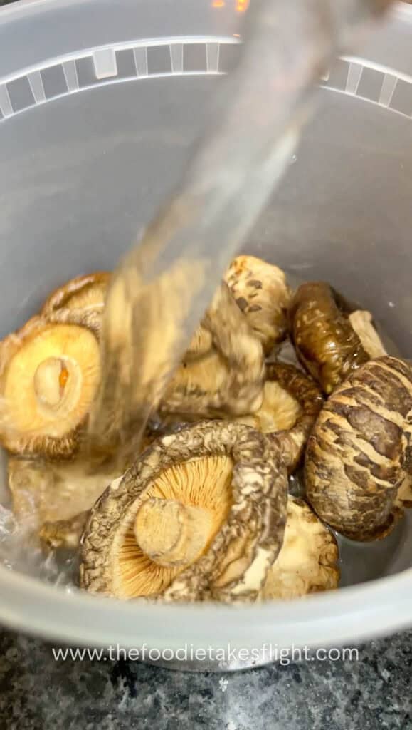 pouring water into dried shiitake mushrooms in a deli container