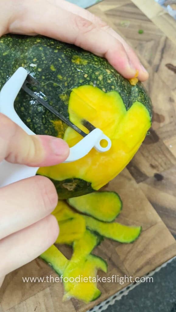 peeling pumpkin on a cutting board