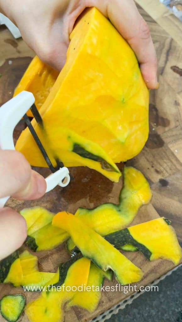 peeling pumpkin on a wooden cutting board