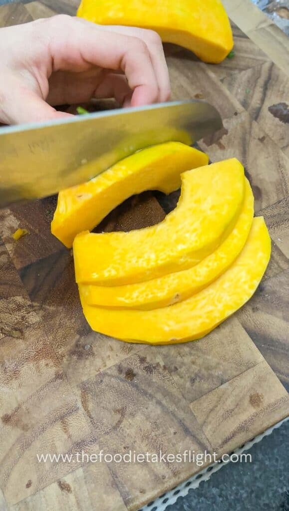 slicing pumpkin on a wooden cutting board
