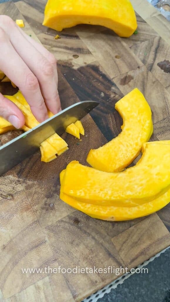 slicing pumpkin on a wooden cutting board