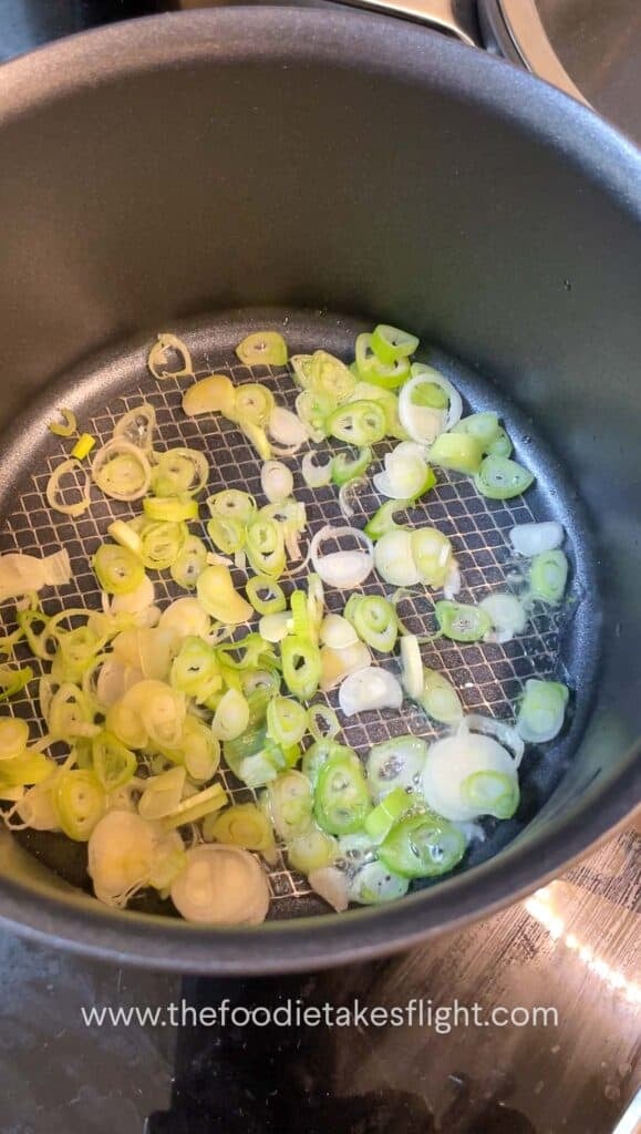 green onions sautéing in a pot