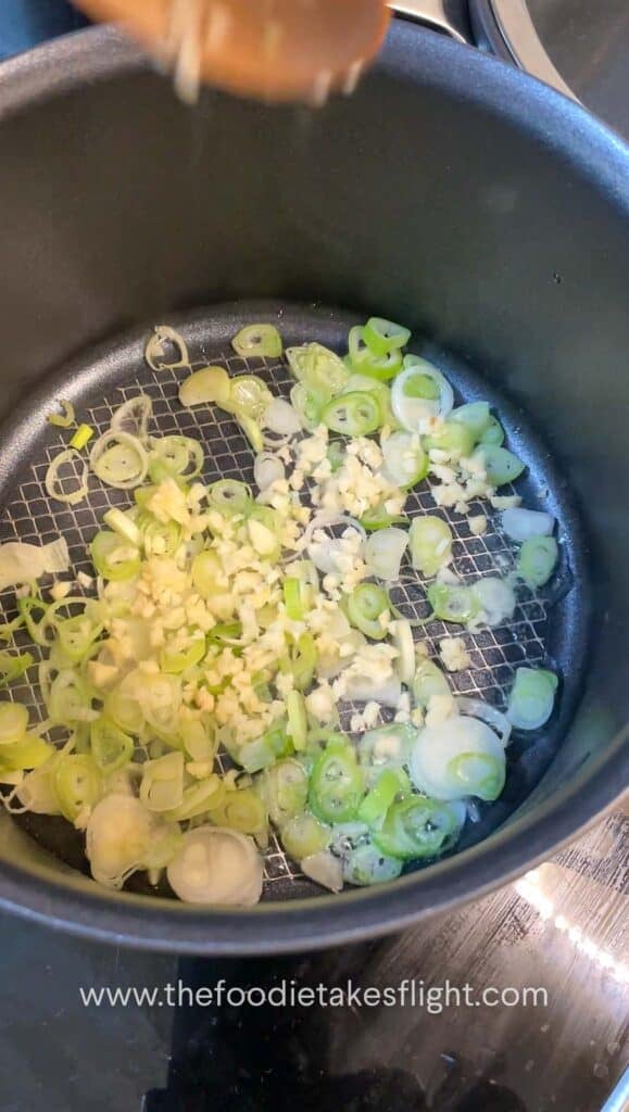 green onions and minced garlic sautéing in a pot