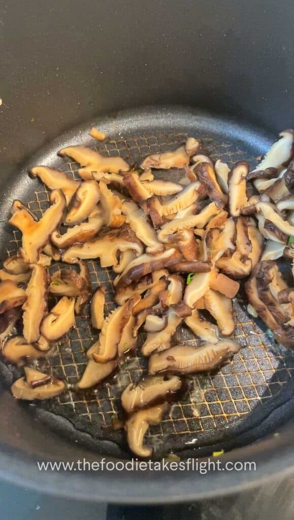 Mushrooms being sautéed until browned and fragrant in the same pot