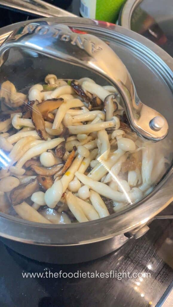 Layered mushrooms and pumpkin on top of seasoned rice before cooking