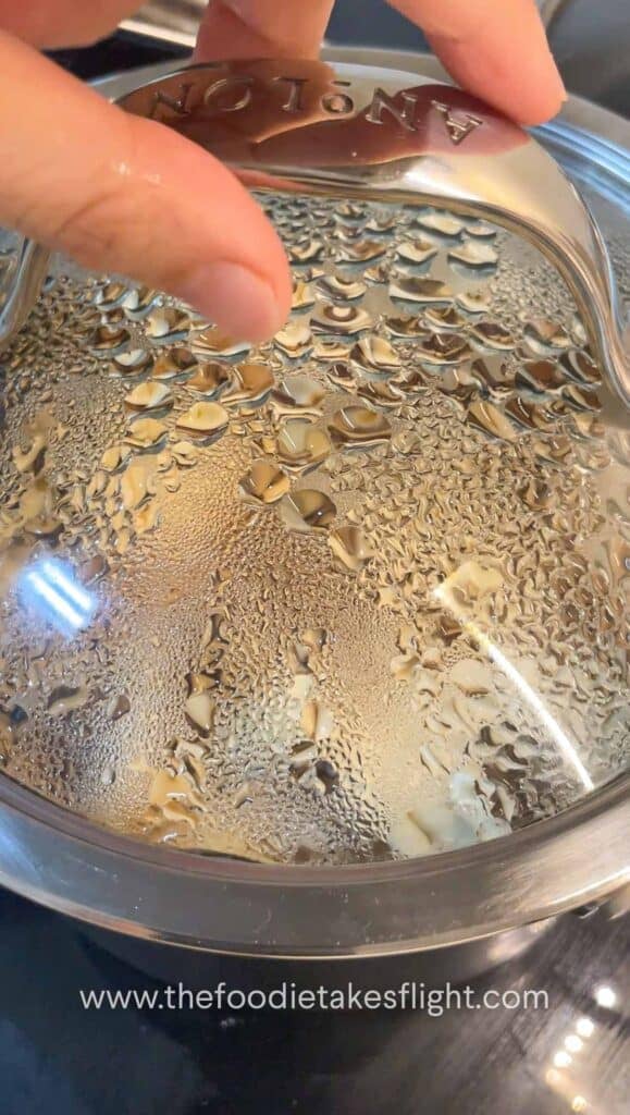 Steaming pot of pumpkin mushroom rice after cooking, ready to fluff