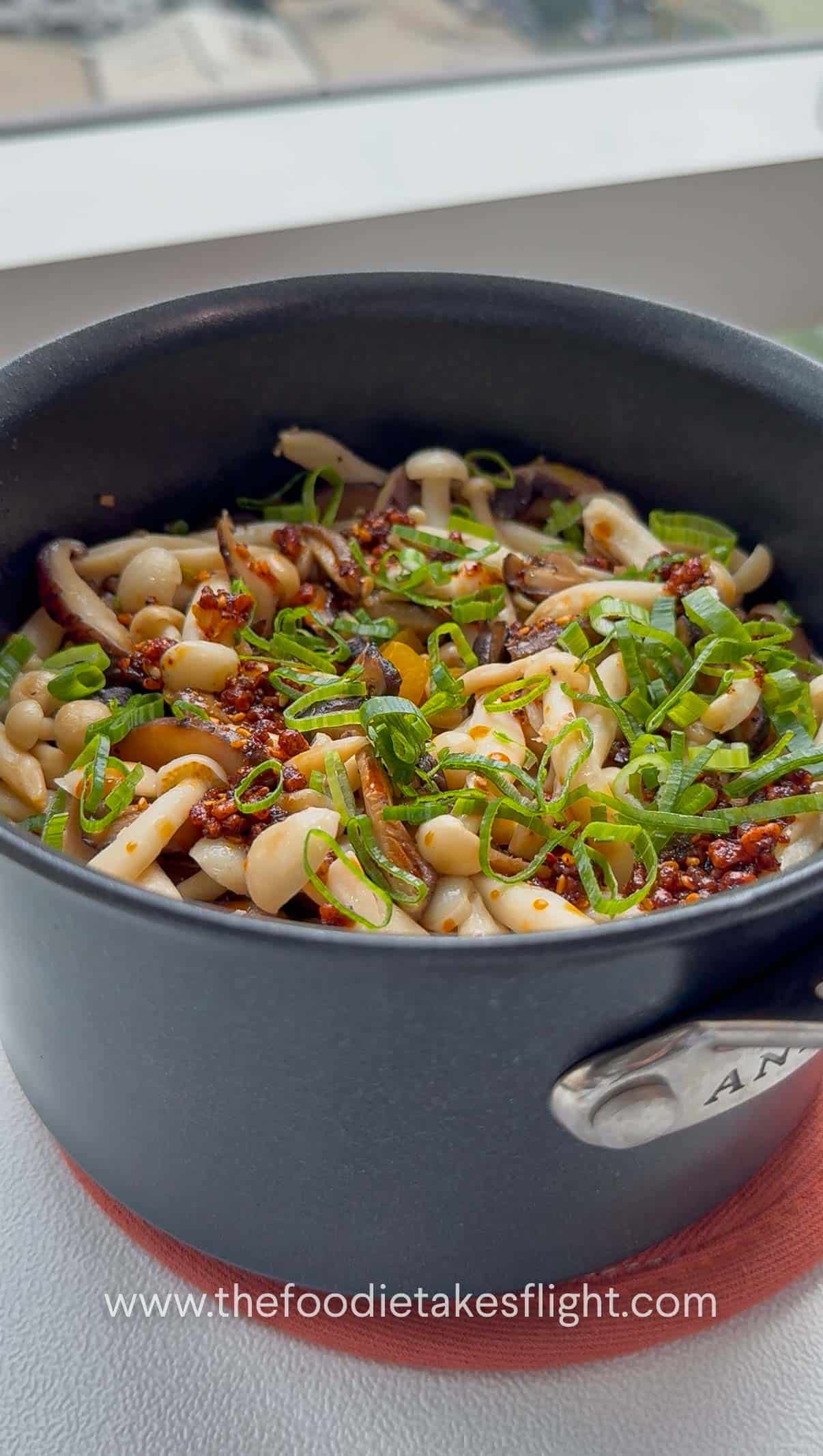 Close-up of pumpkin mushroom pot rice topped with green onions and chili oil