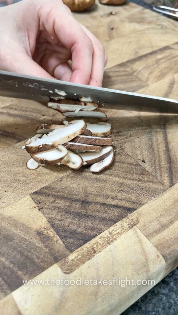 slicing fresh shiitake mushrooms on a bias