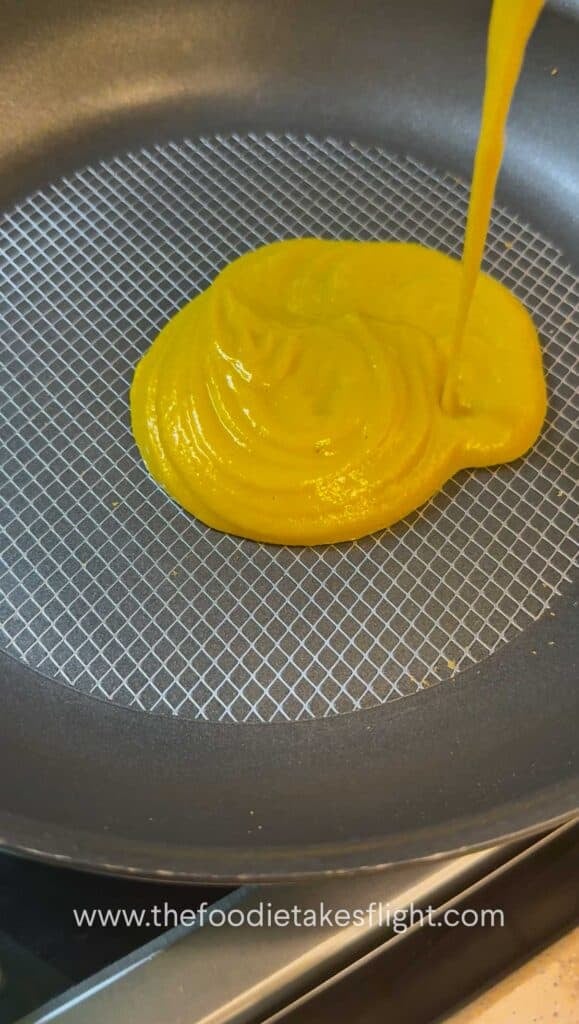 Blended pumpkin miso sauce being poured into a skillet