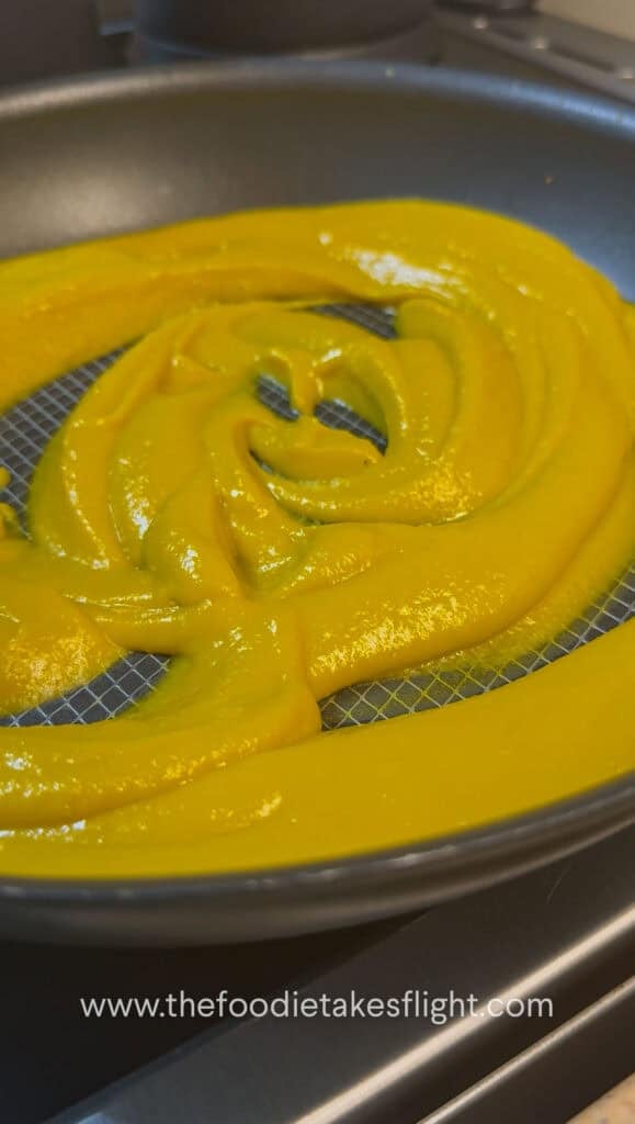 Blended pumpkin miso sauce being poured into a skillet