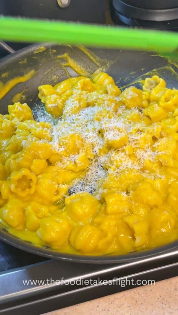 Tossing cooked pasta in creamy pumpkin miso sauce