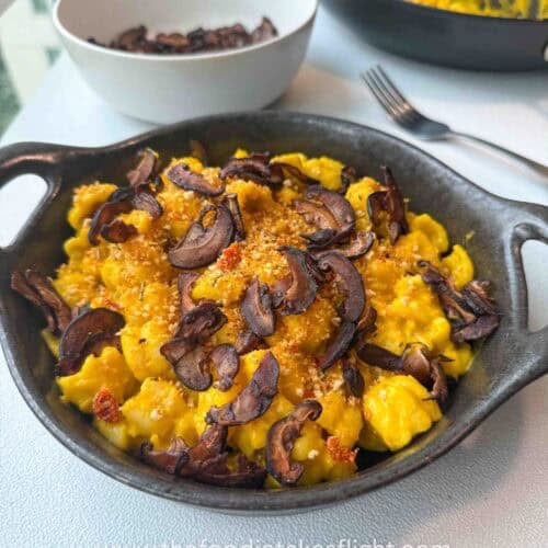 Finished pumpkin miso pasta garnished with chili breadcrumbs and shiitake bacon on a g