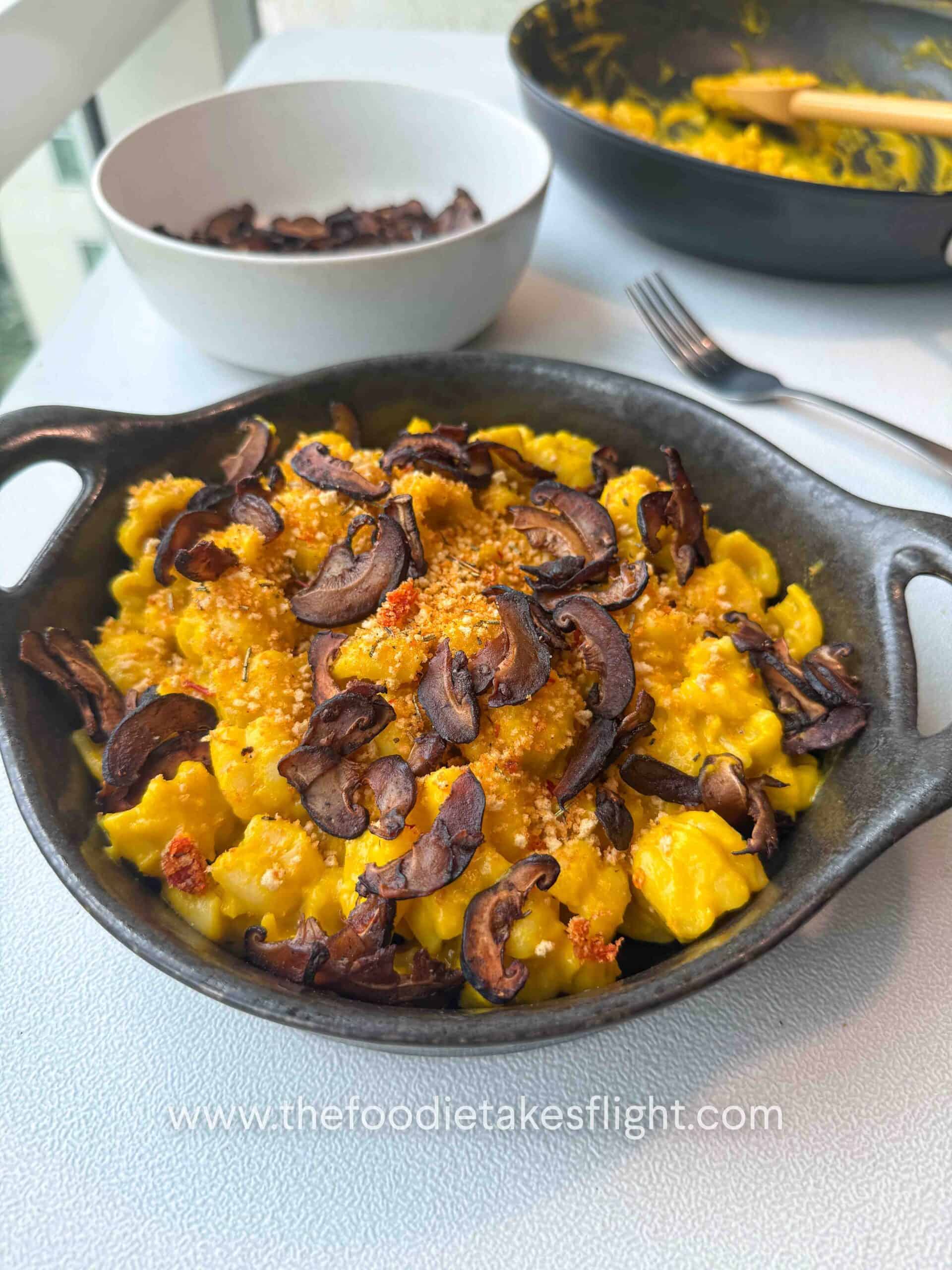 Finished pumpkin miso pasta garnished with chili breadcrumbs and shiitake bacon on a g