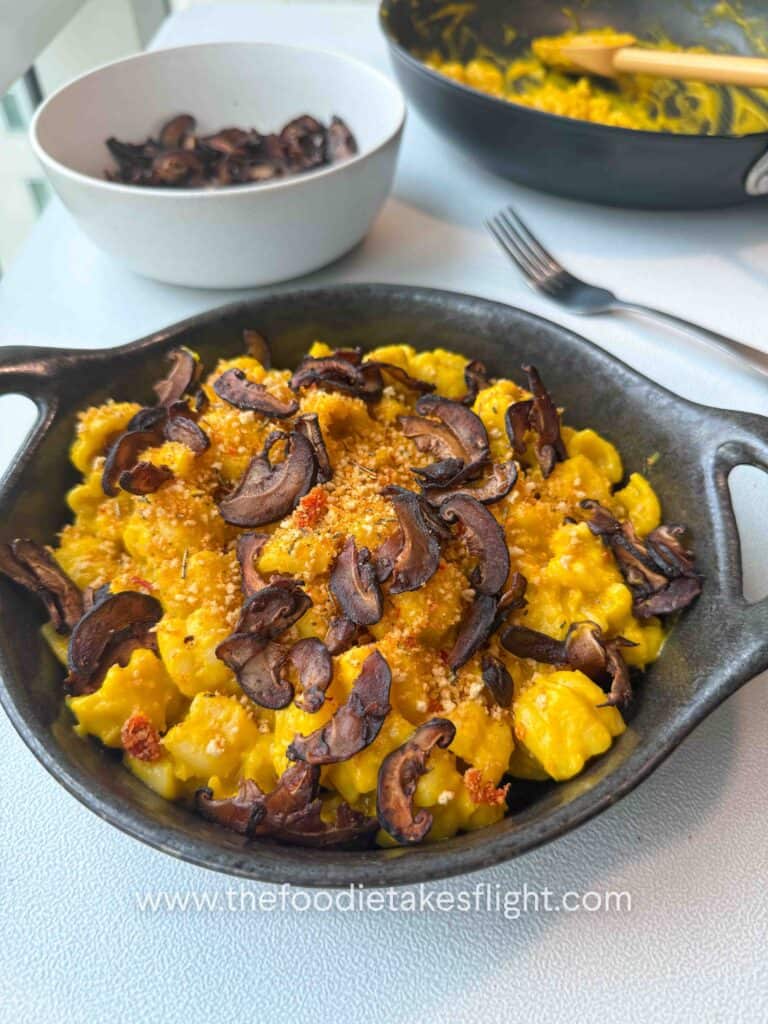 Finished pumpkin miso pasta garnished with chili breadcrumbs and shiitake bacon on a g