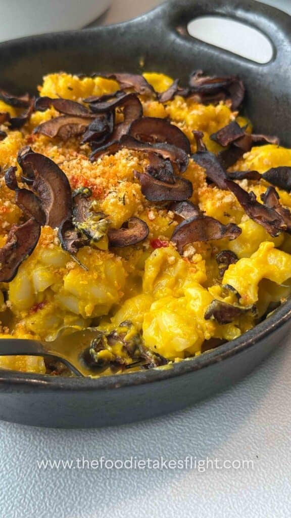 Finished pumpkin miso pasta garnished with chili breadcrumbs and shiitake bacon on a g