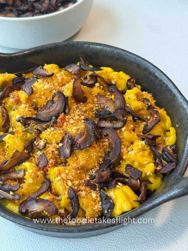 Finished pumpkin miso pasta garnished with chili breadcrumbs and shiitake bacon on a g