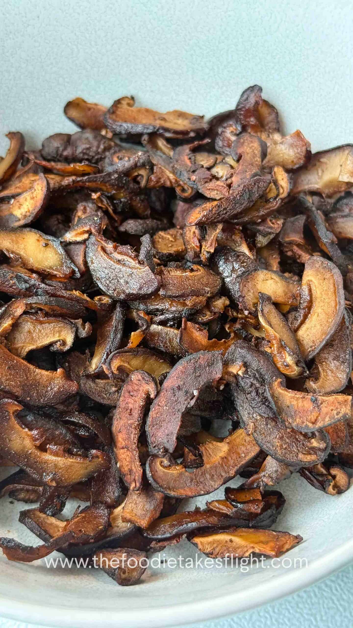 close up of shiitake mushroom bacon in a white bowl