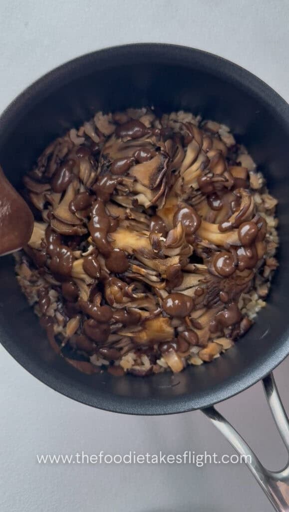 overhead shot of pot of rice topped with maitake mushrooms