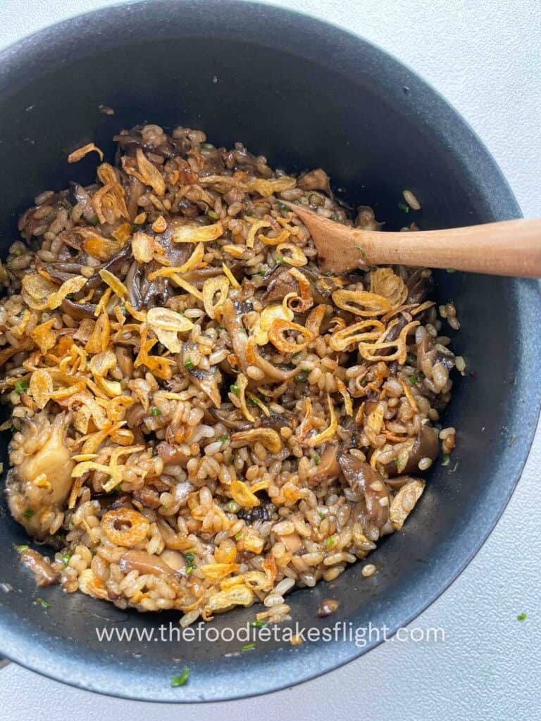rice pot filled with glazed maitake mushrooms, black garlic miso sauce and chives