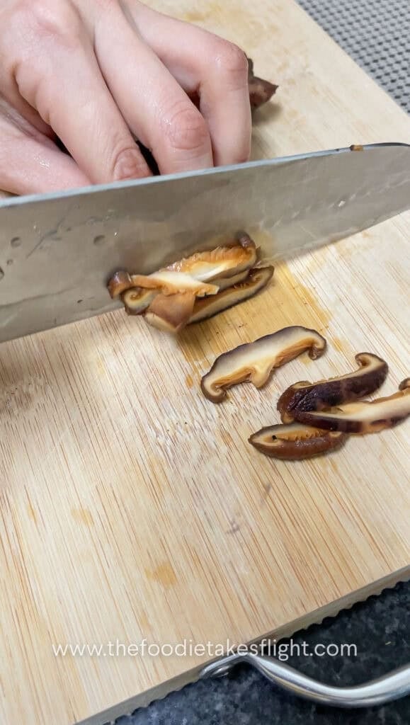 slicing rehydrated shiitake mushrooms