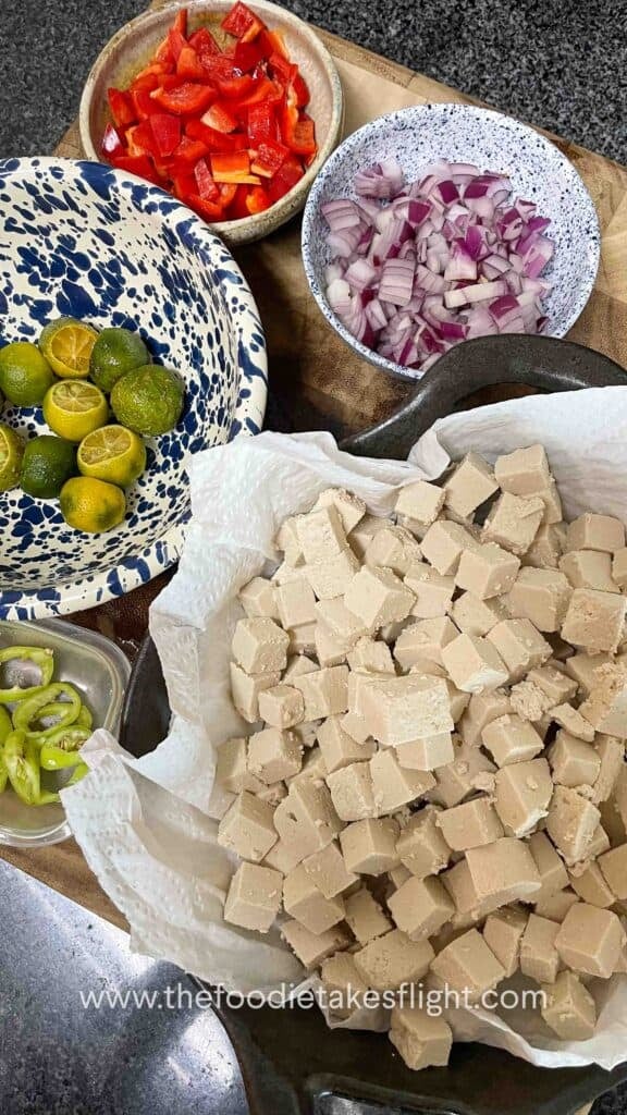 flat lay of ingredients for the stir-fried tofu with oyster sauce - diced onions, peppers, chili, tofu cubes, and calamansi