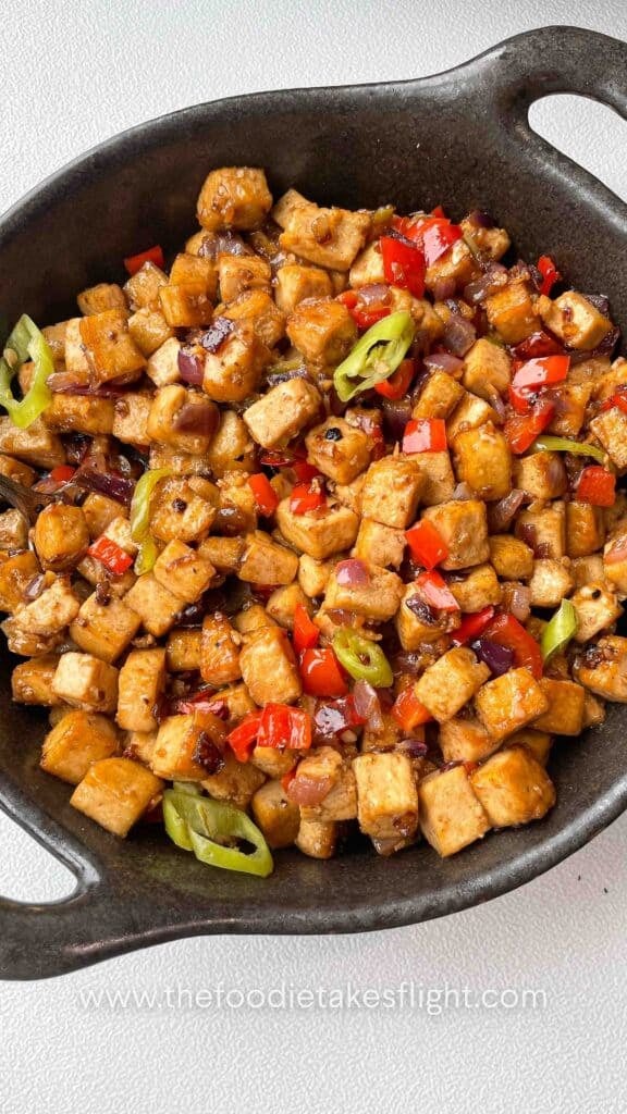 Plate of Filipino-style tofu stir-fry with onions, bell peppers, and chili