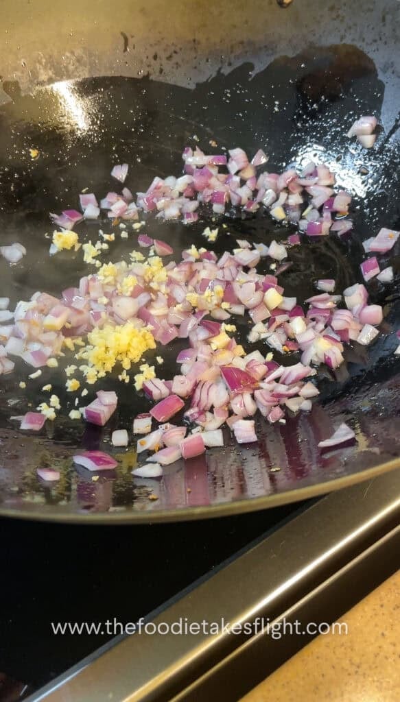 Diced onions, garlic, and bell peppers sautéing in a wok