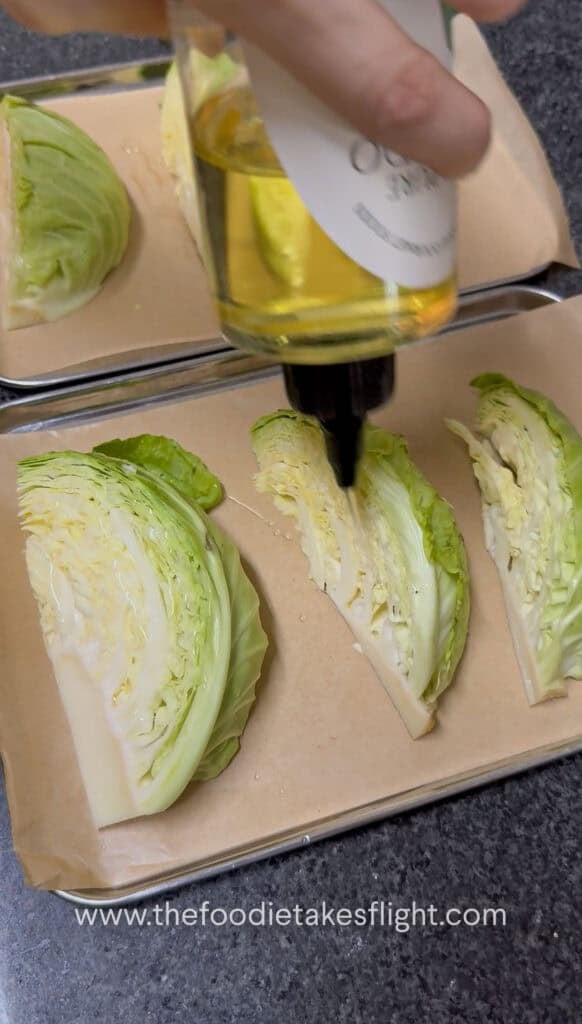 Raw cabbage sliced into wedges and arranged on a baking tray