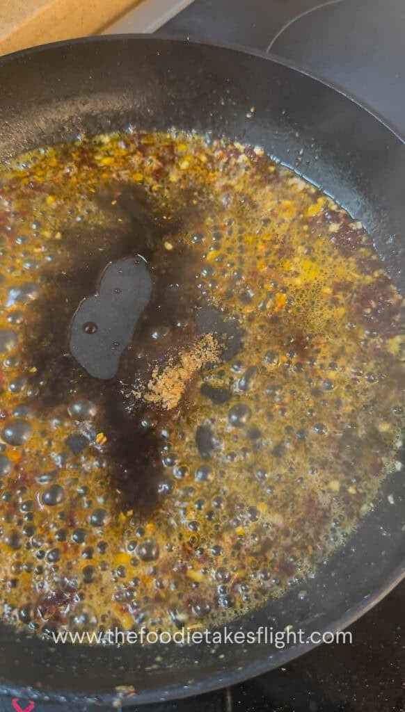 Gochujang butter sauce simmering in a pan with mirin and soy sauce
