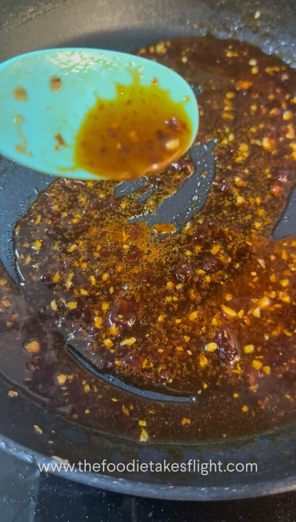 Gochujang butter sauce simmering in a pan with mirin and soy sauce