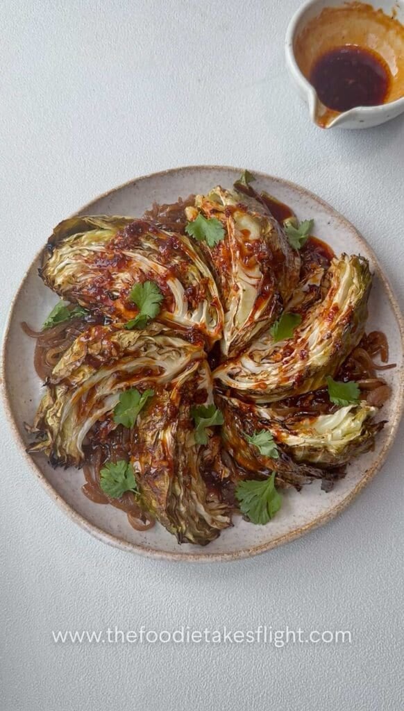 Charred cabbage wedges served over caramelised onions and drizzled with gochujang butter sauce