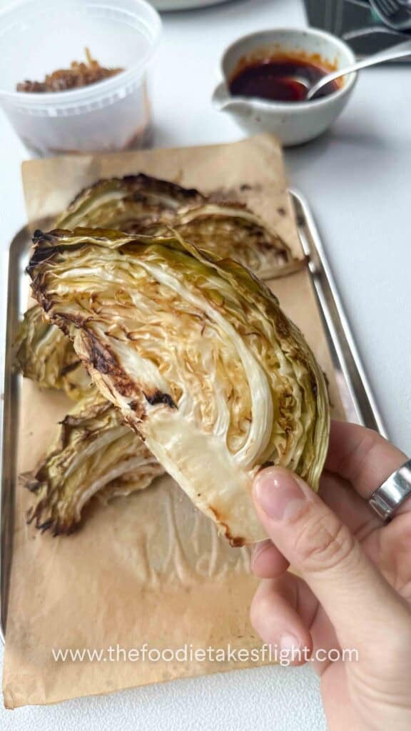 charred cabbage wedges on a lined baking tray