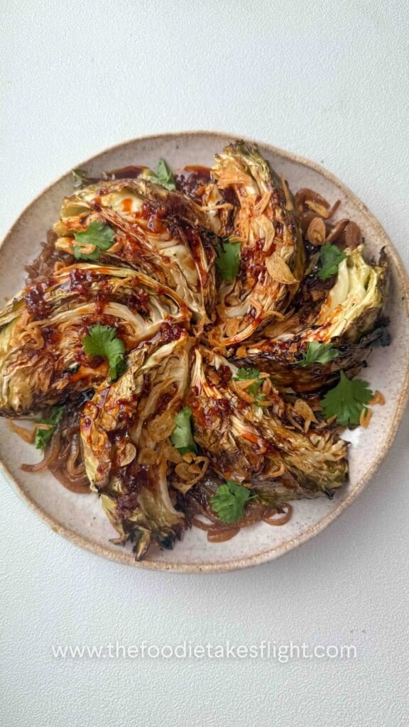 Charred cabbage wedges served over caramelised onions and drizzled with gochujang butter sauc