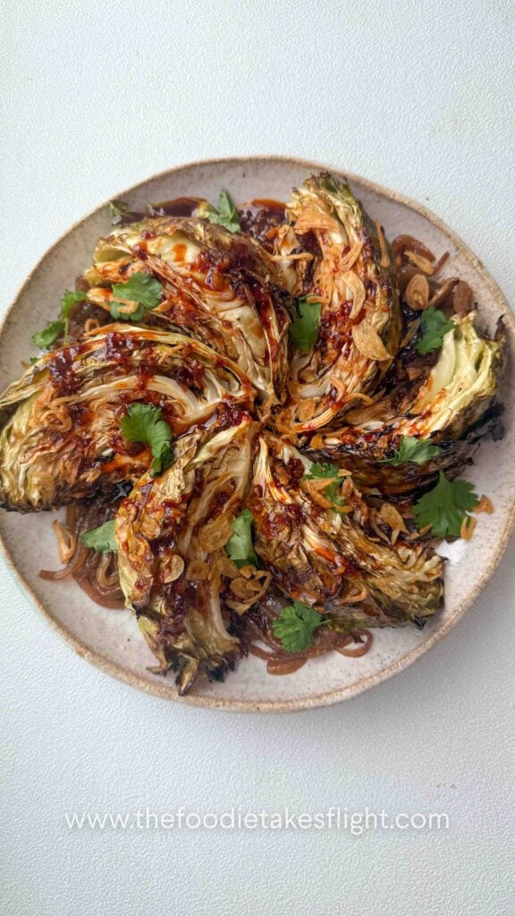 Charred cabbage wedges served over caramelised onions and drizzled with gochujang butter sauce