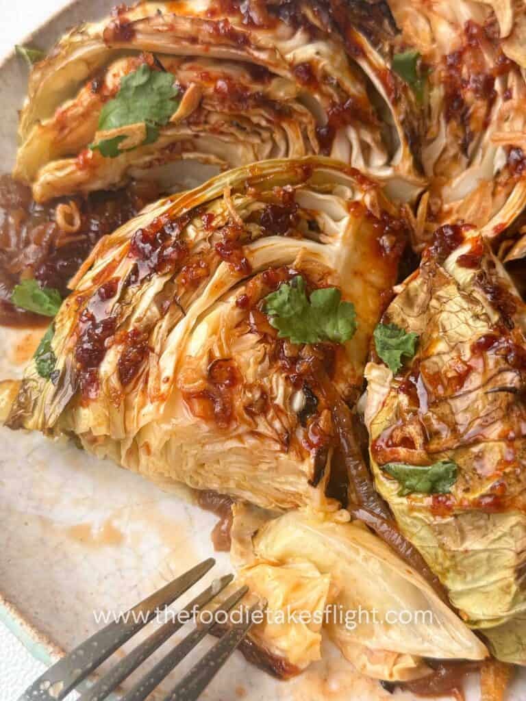 Close up shot of cabbage wedges finished with gochujang butter sauce and cilantro