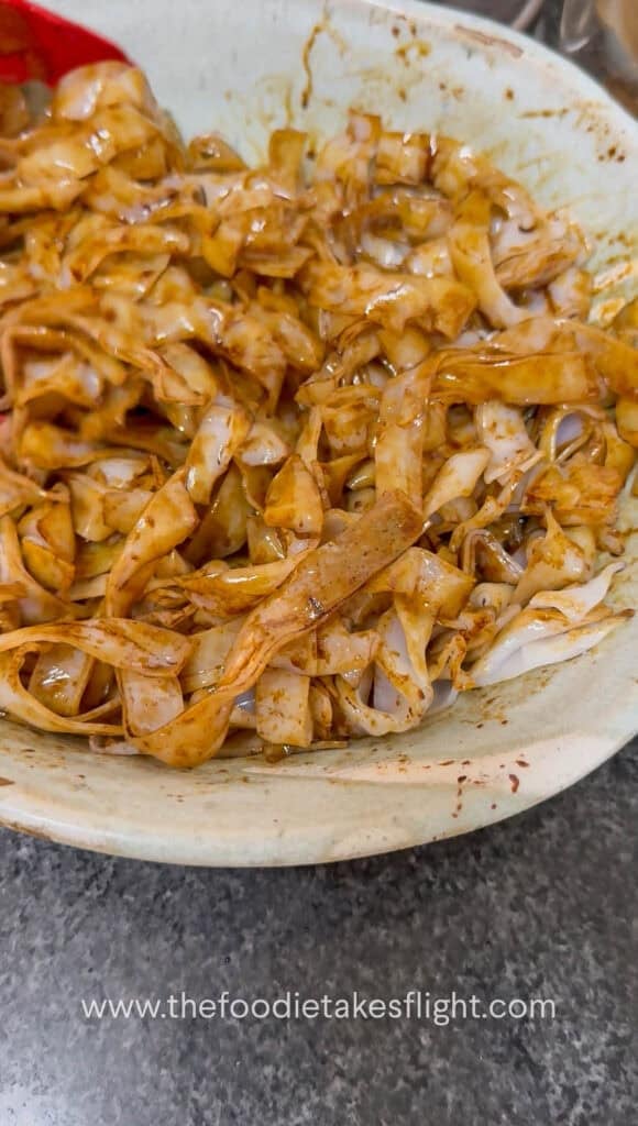 Rice noodles tossed with soy sauce before stir-frying in a wok