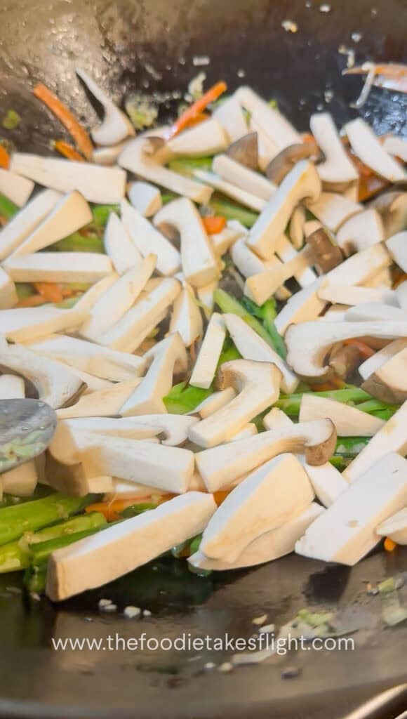 Vegetables and mushrooms stir-fried in a wok before adding gravy